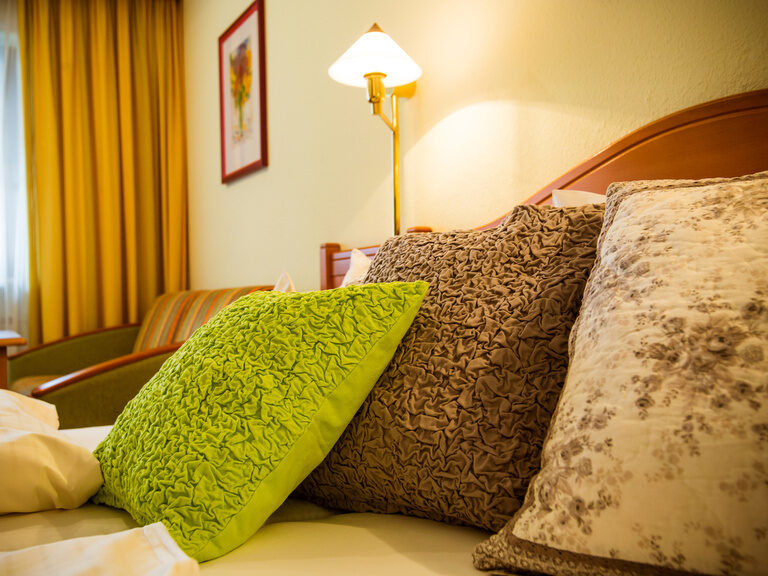 Ein gemütliches Bett mit zwei Kissen im stilvollen Hotelzimmer.