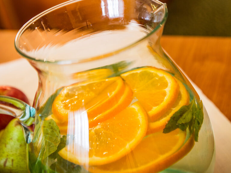 Ein Krug mit Orangenscheiben auf einem Tisch in einem Zimmer.