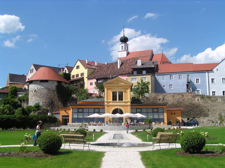 Mehrere Häuser in Schärding, eingebettet in die grüne Natur des Orangerieparks, perfekt für einen erholsamen Spaziergang.